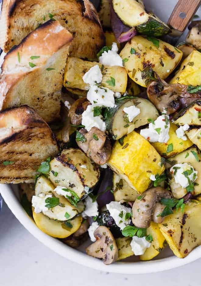 Close up of grilled zucchini, summer squash, mushrooms, and goat cheese. 