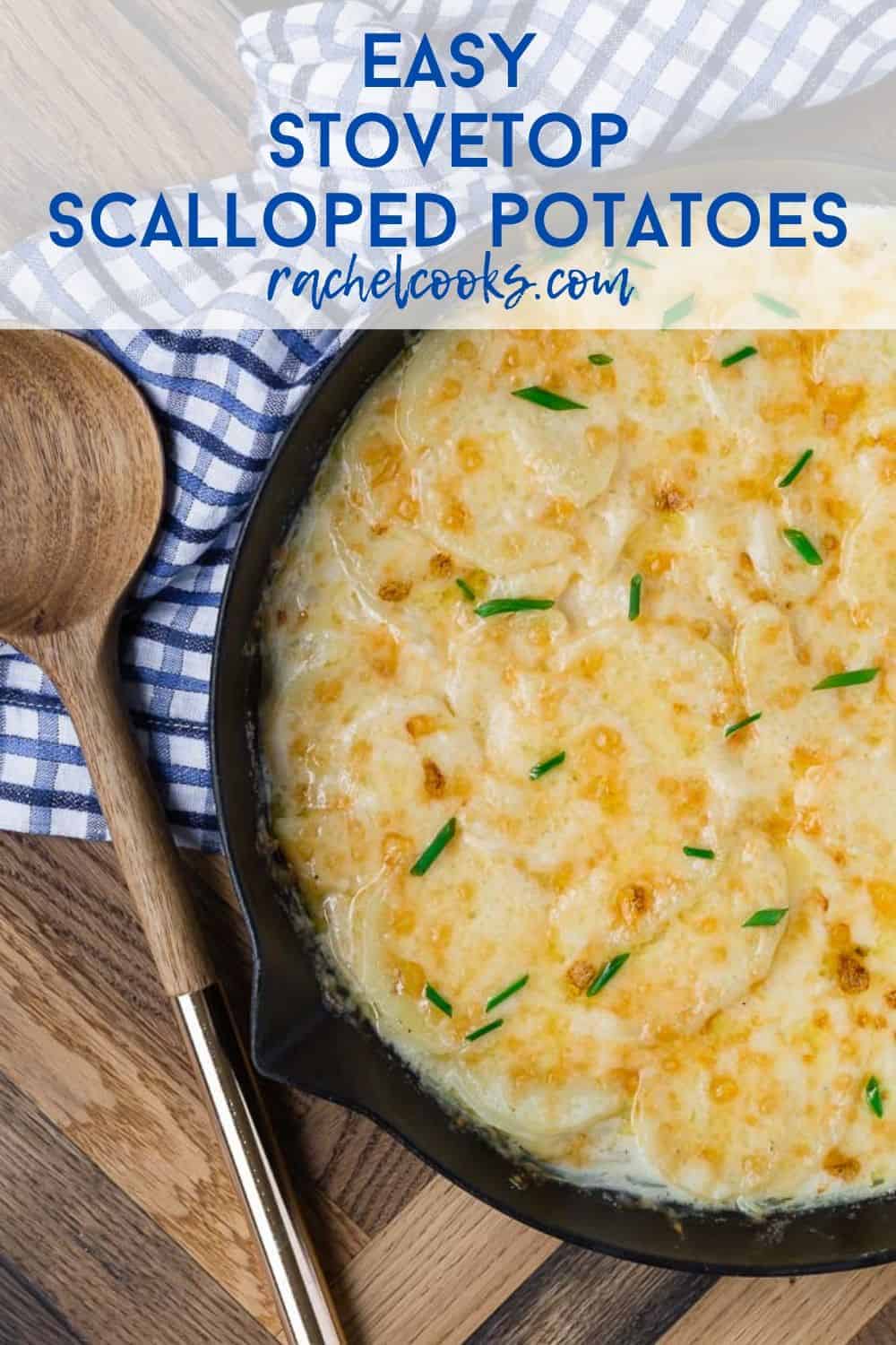 Scalloped potatoes in a skillet on a wooden background. Text overlay with recipe title.
