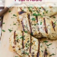 Grilled chicken breasts on a wooden cutting board. Text overlay reads "Italian Chicken Marinade."