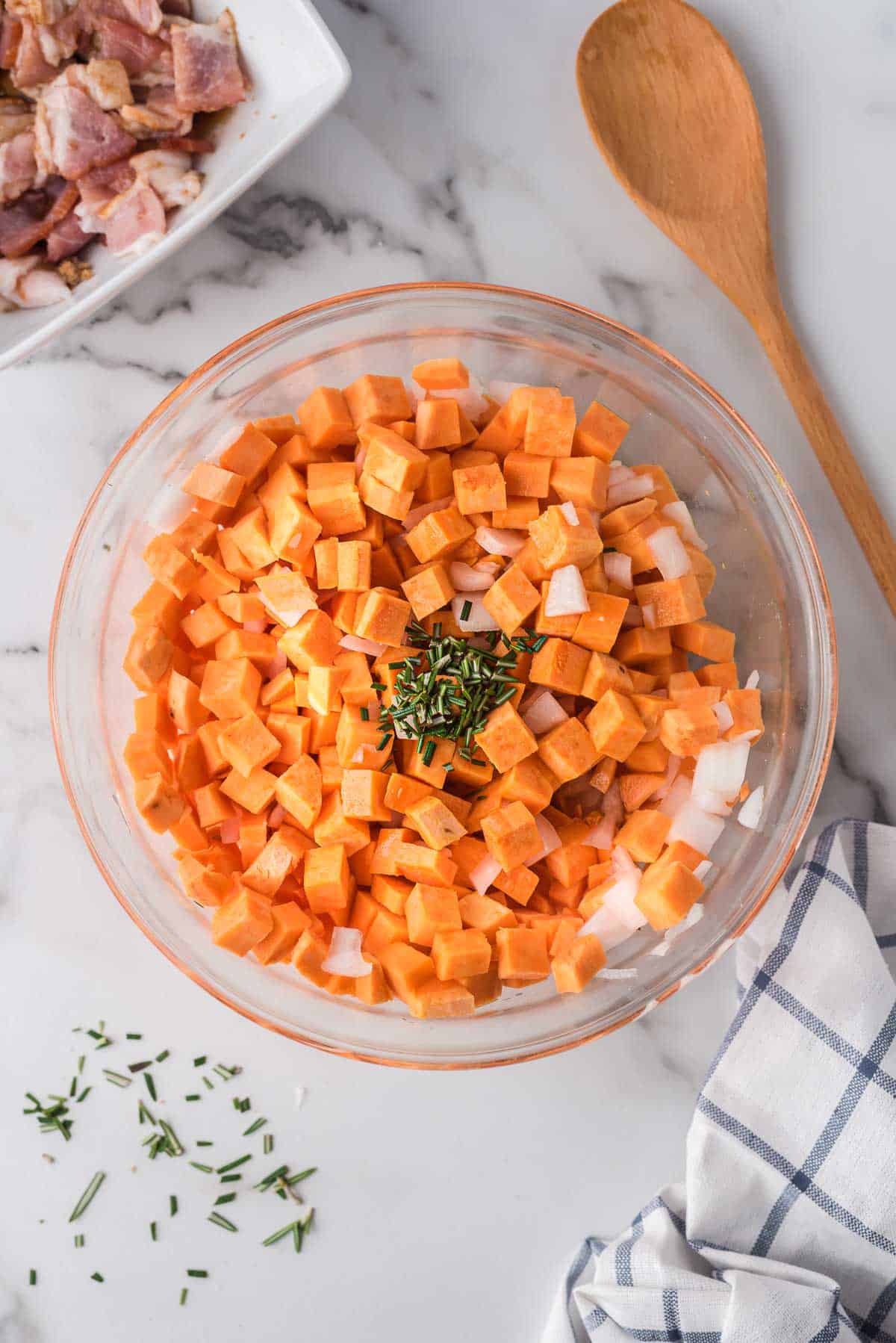Bowl of sweet potatoes, onion, and rosemary.