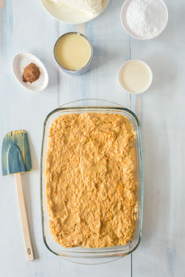 Pumpkin poke cake batter spread into a 9x13-inch cake pan.