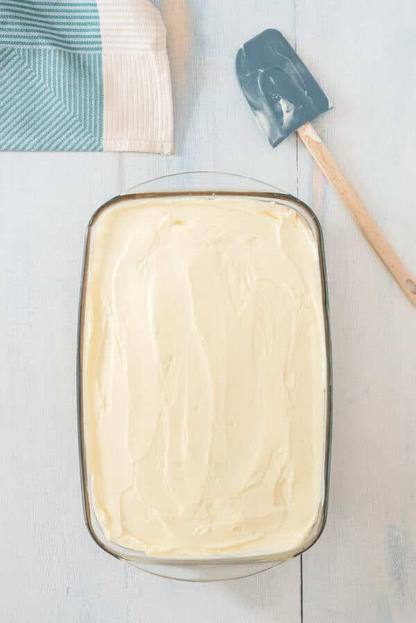 Frosted pumpkin poke cake on a countertop.