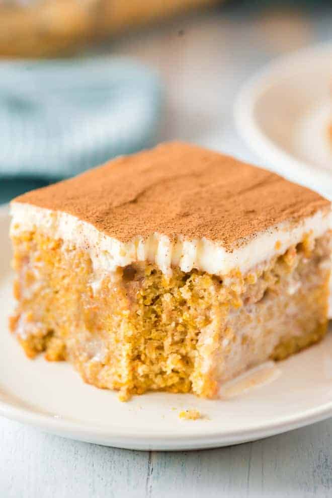 Close up of a slice of pumpkin cake, a bite has been taken out of it with a fork.