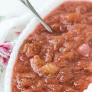 Light red sauce in a white oval bowl. Text overlay reads "rhubarb sauce - two ingredients!"