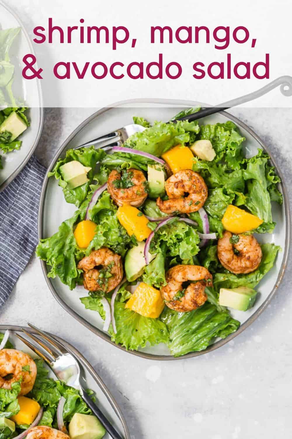 Overhead view of a colorful salad with shrimp, mango and avocado. Text overlay reads, "shrimp, mango, and avocado salad."