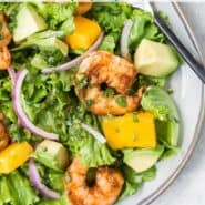 Overhead view of a colorful salad with shrimp, mango and avocado. Text overlay reads, "shrimp & mango salad."