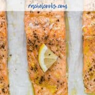 Three salmon fillets on a parchment paper lined sheet pan. Each is topped with pepper and a lemon wedge. Text overlay reads "slow roasted lemon pepper salmon."