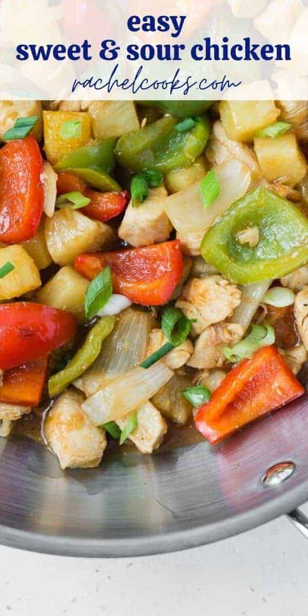 Sweet and sour chicken in a wok, rice and green onions also pictured.