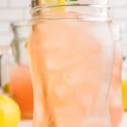 A light pink drink in a tall clear glass, garnished with lemon and fresh mint. Text overlay reads "watermelon mint lemonade - with or without vodka."