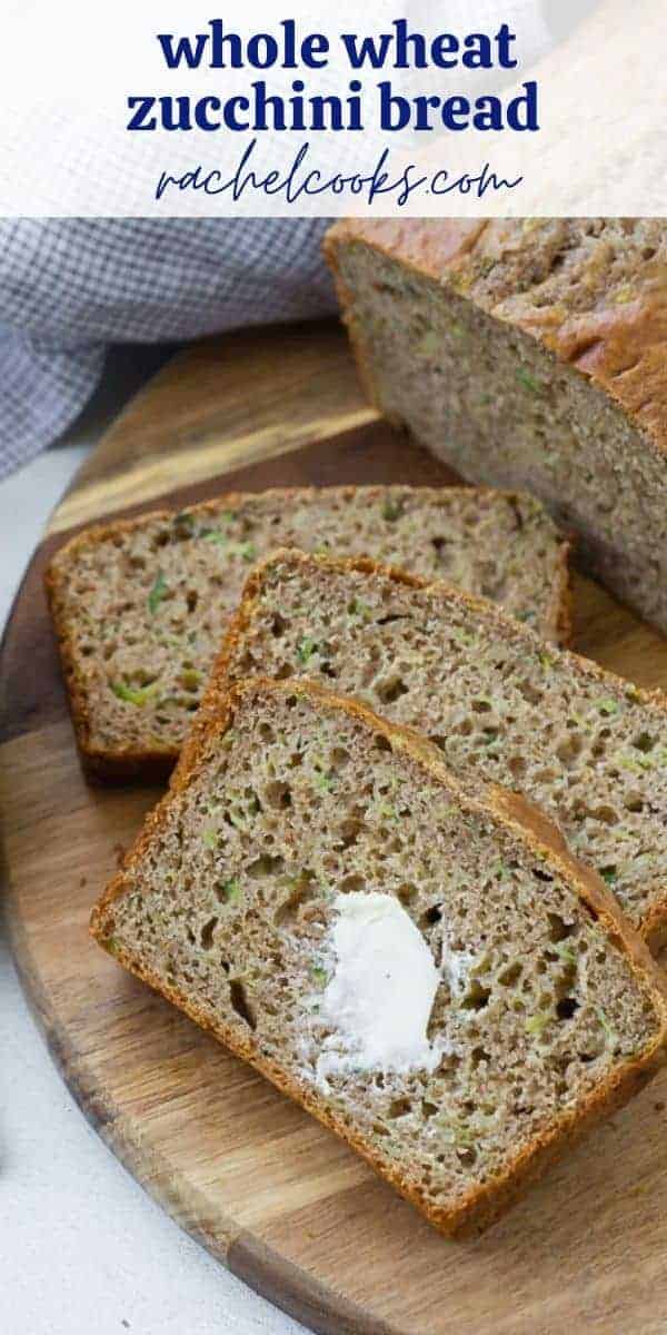 Overhead view of sliced zucchini bread, with a dab of butter on it. A text overlay reads "whole wheat zucchini bread."