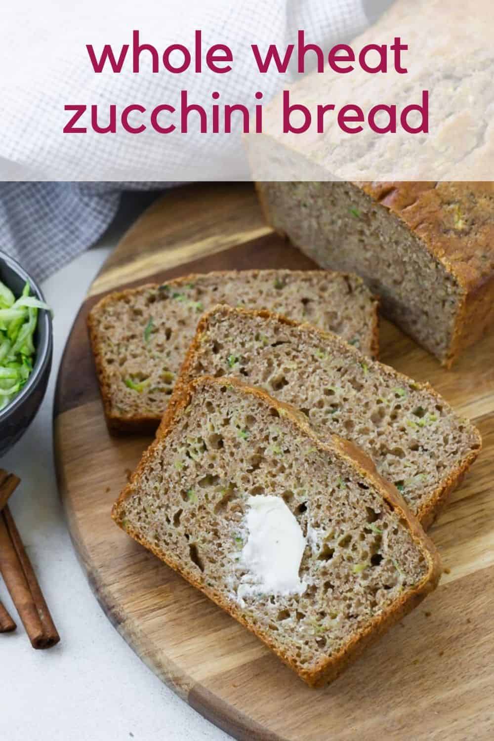 Overhead view of sliced zucchini bread, with a dab of butter on it. A text overlay reads "whole wheat zucchini bread."