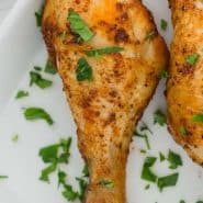 Chicken legs on a white plate, text overlay reads "easy air fryer chicken drumsticks"