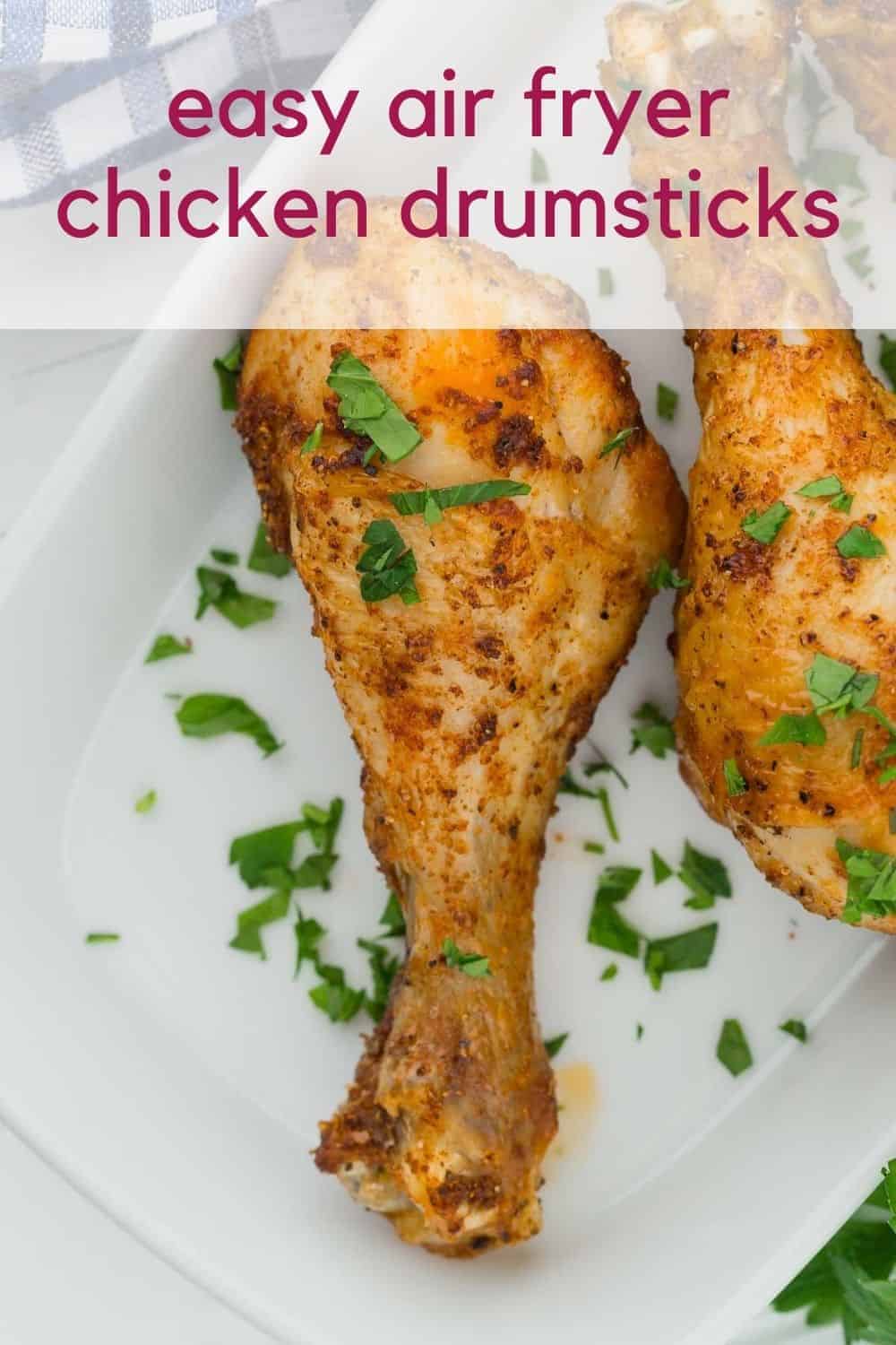 Chicken legs on a white plate, text overlay reads "easy air fryer chicken drumsticks"