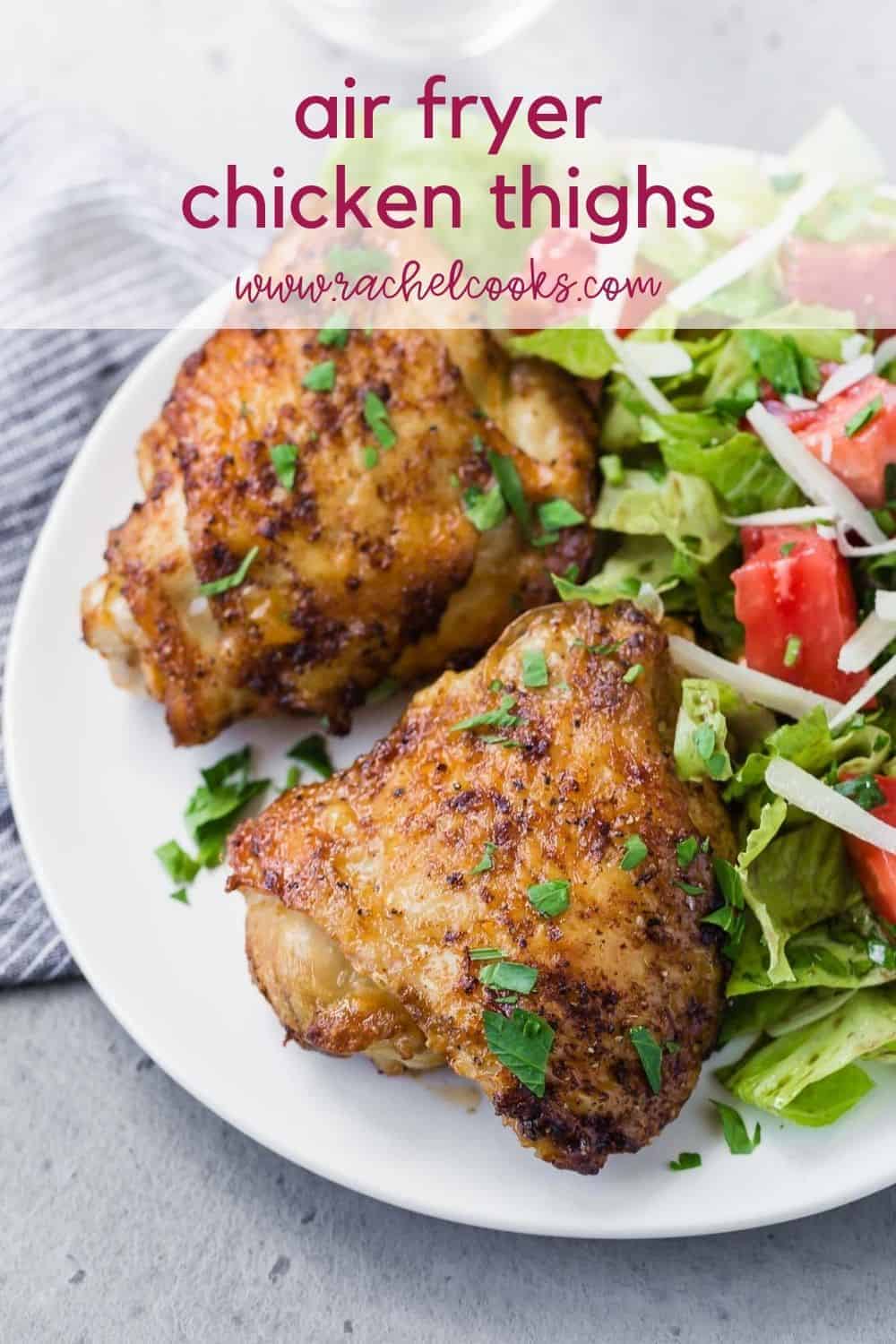 Two chicken thighs on a plate with salad, text overlay reads "air fryer chicken thighs, www.rachelcooks.com"