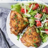 Two chicken thighs on a plate with salad, text overlay reads "the best air fryer chicken thighs, www.rachelcooks.com"