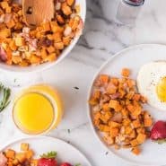 Overhead view of plates of sweet potatoes and fried eggs, text overlay reads "air fryer sweet potato hash with candied bacon"