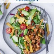 Colorful chopped salad on a plate - includes bbq chicken, avocado, tomatoes, corn, onion. Text overlay reads "bbq chicken chopped salad."