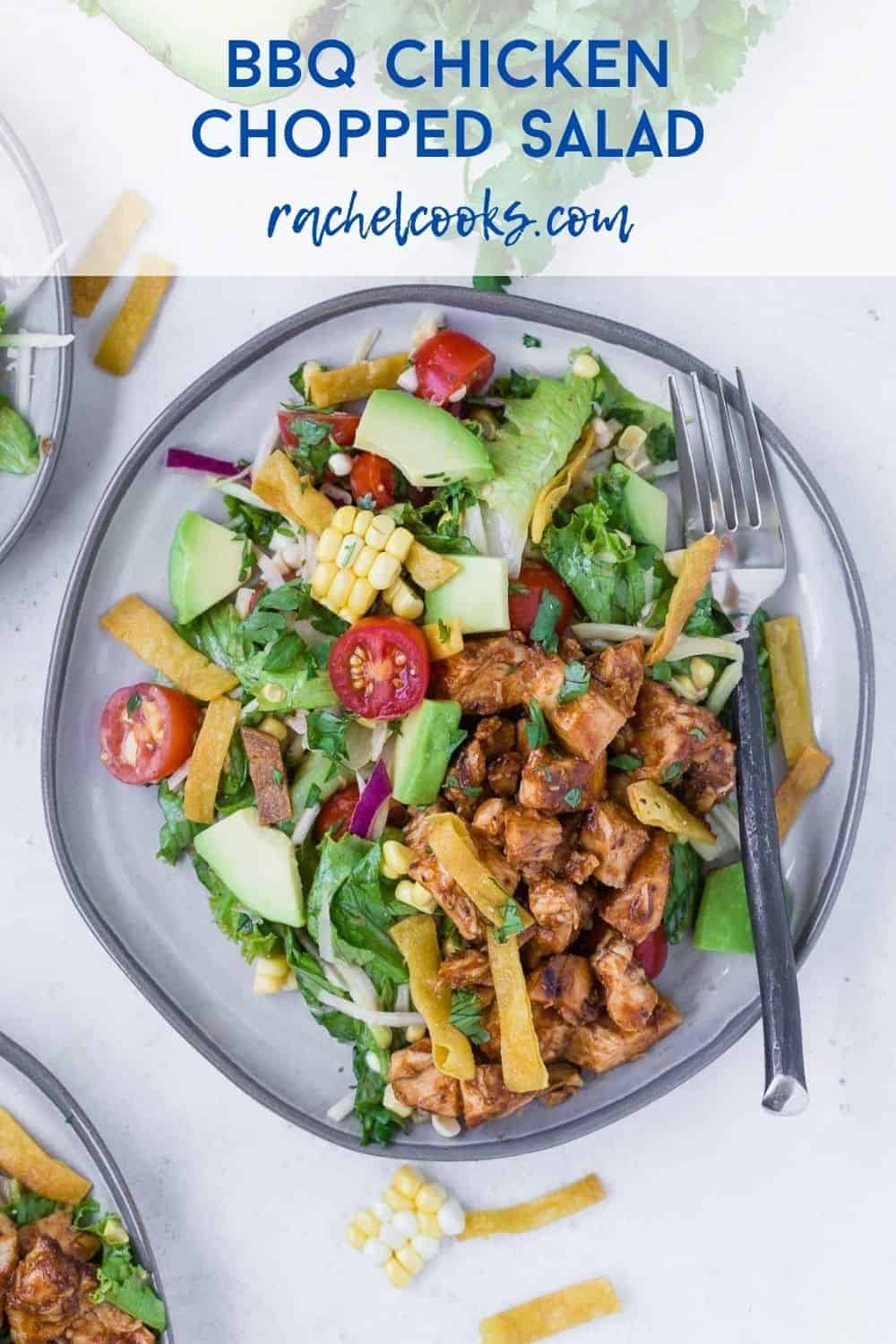 Colorful chopped salad on a plate - includes bbq chicken, avocado, tomatoes, corn, onion. Text overlay reads "bbq chicken chopped salad."