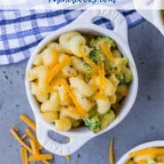 Overhead view of a small white bowl full of pasta and broccoli. Text overlay reads "instant pot broccoli mac and cheese"