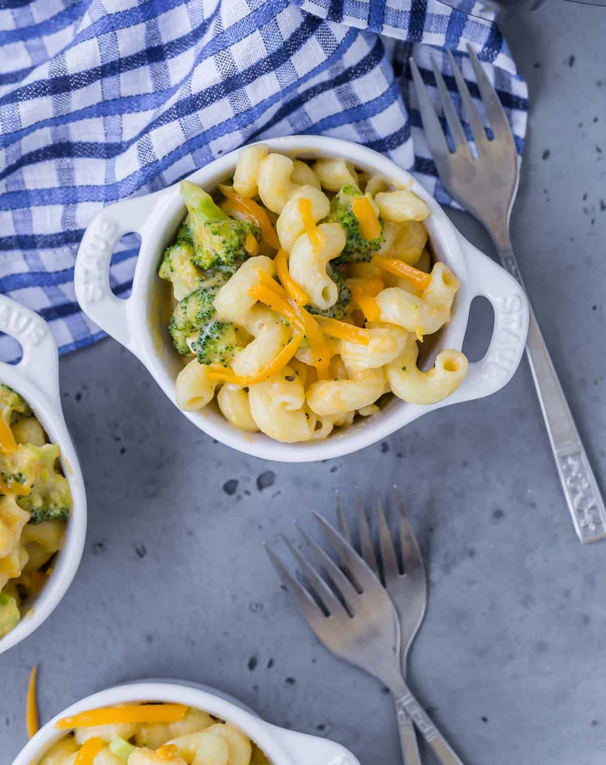 Overhead view of mac and cheese with broccoli in a small white bowl.