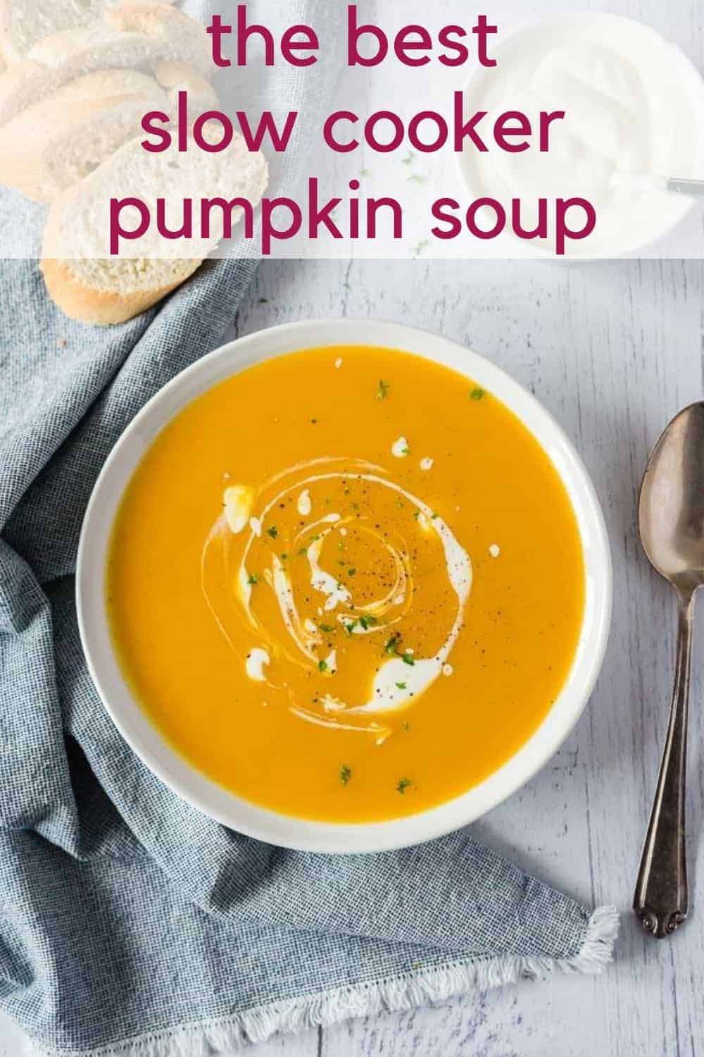 Overhead view of pumpkin soup in a white bowl. Text overlay reads "the best slow cooker pumpkin soup"