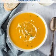Overhead view of orange soup in a white bowl. Text overlay reads "slow cooker pumpkin soup: rachelcooks.com"