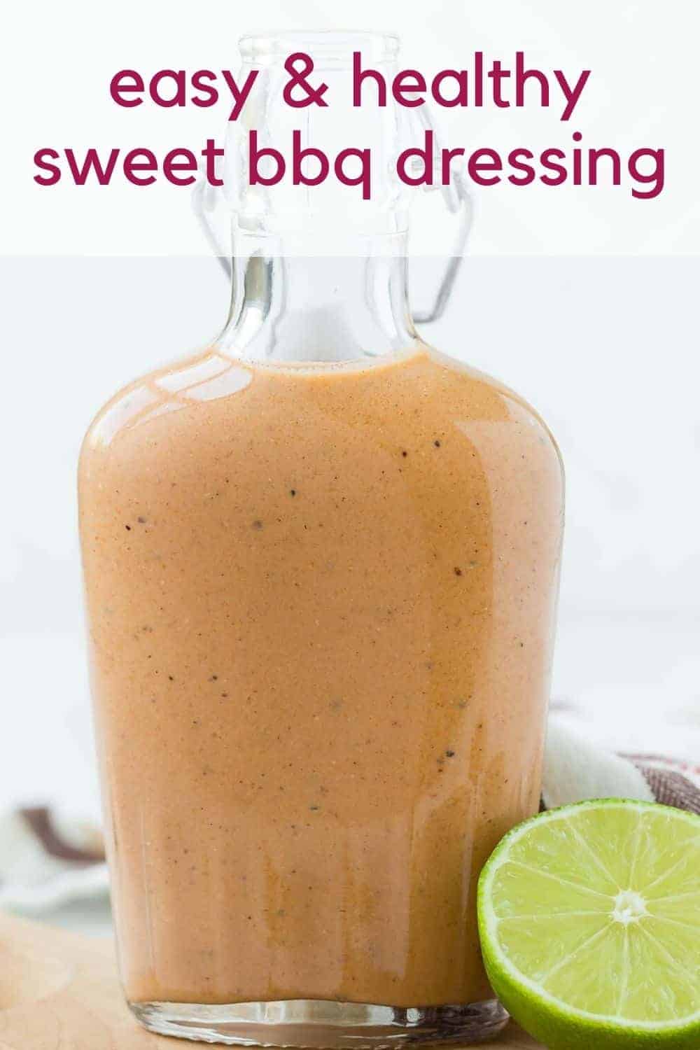 Small glass bottle of sweet bbq salad dressing on a wooden cutting board. Text overlay reads "sweet bbq dressing"