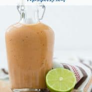 Small glass bottle of sweet bbq salad dressing on a wooden cutting board. Text overlay reads "healthy sweet bbq dressing"