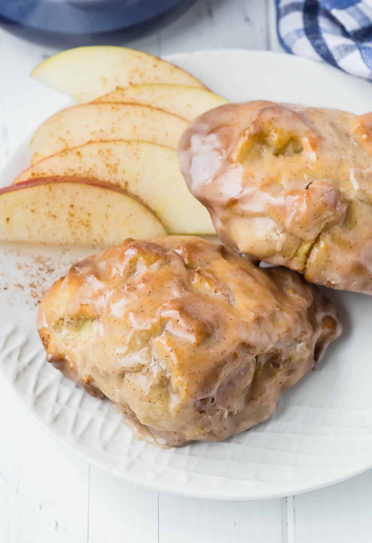 Close up of two air fryer apple fritters with a glaze.