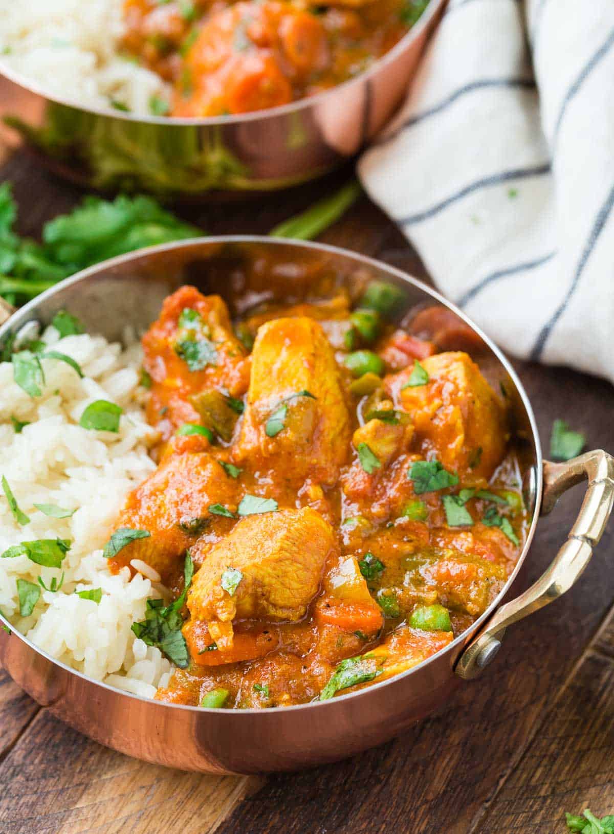 Easy tikka masala made with chicken and served with rice in copper bowls.