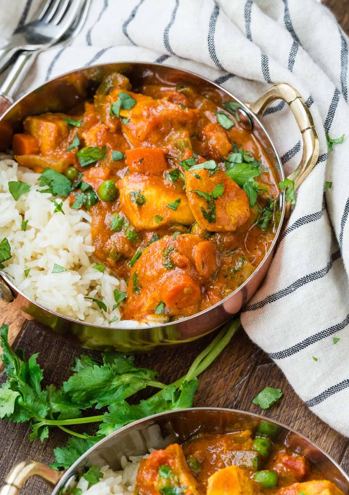 Chicken in a creamy coconut tomato sauce with vegetables, served with rice.