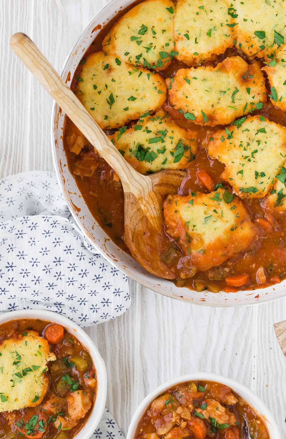 Pan of tomato sauce and chicken, with cornmeal biscuits.