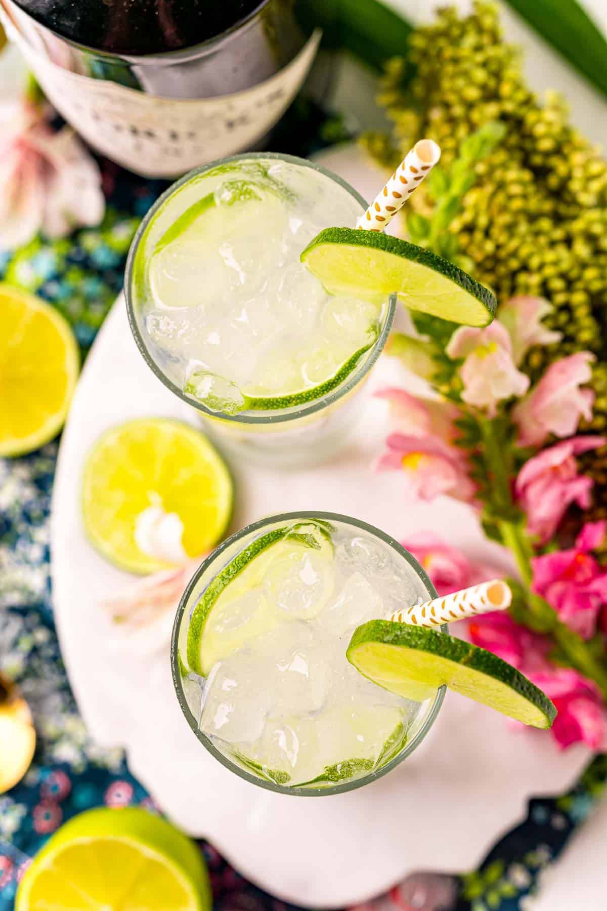 Overhead view of two cocktails with limes.