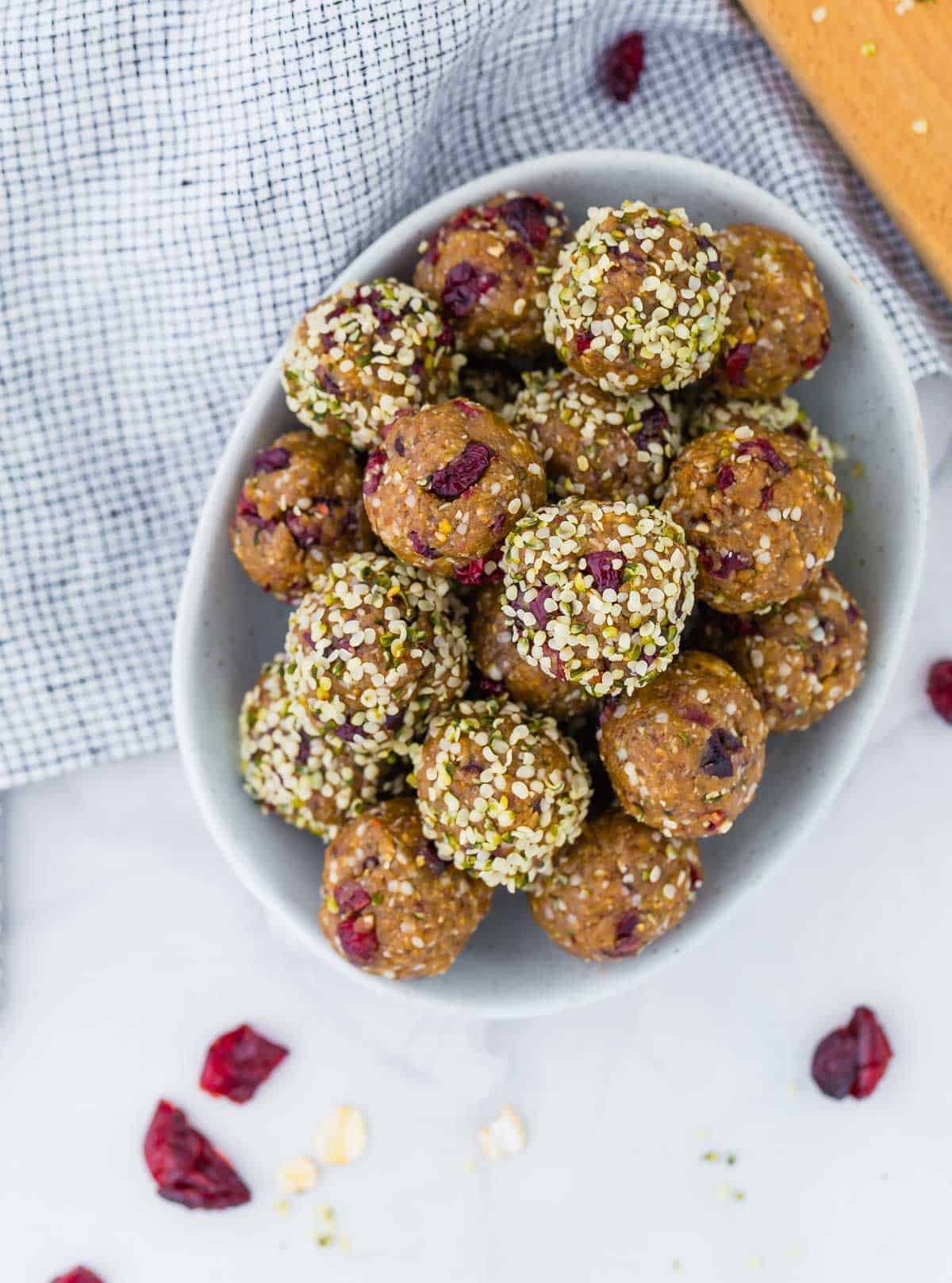 Overhead view of oatmeal energy bites in a bowl, with dried cranberries.