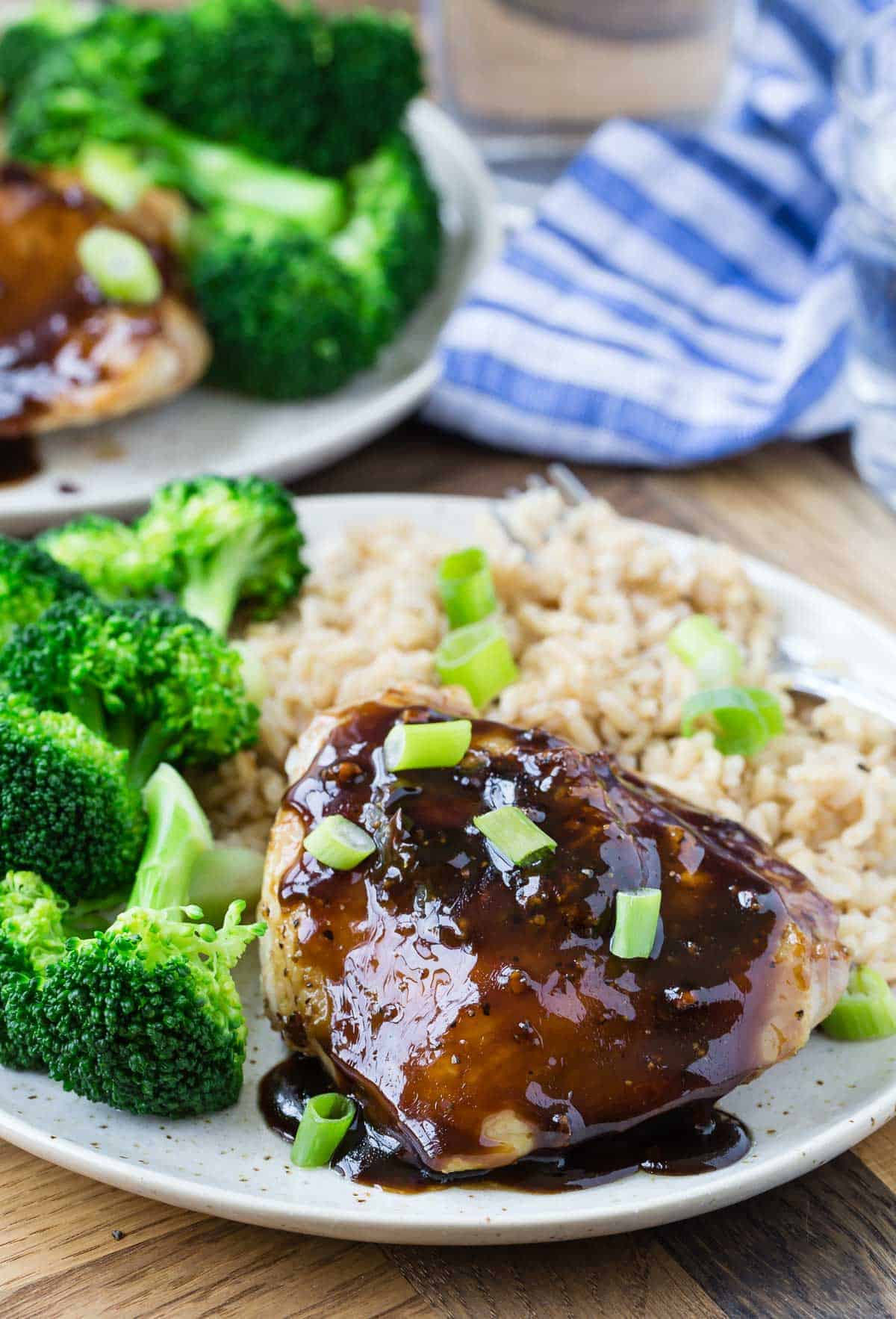 Chicken on a plate with and broccoli. Another plate is in the background.