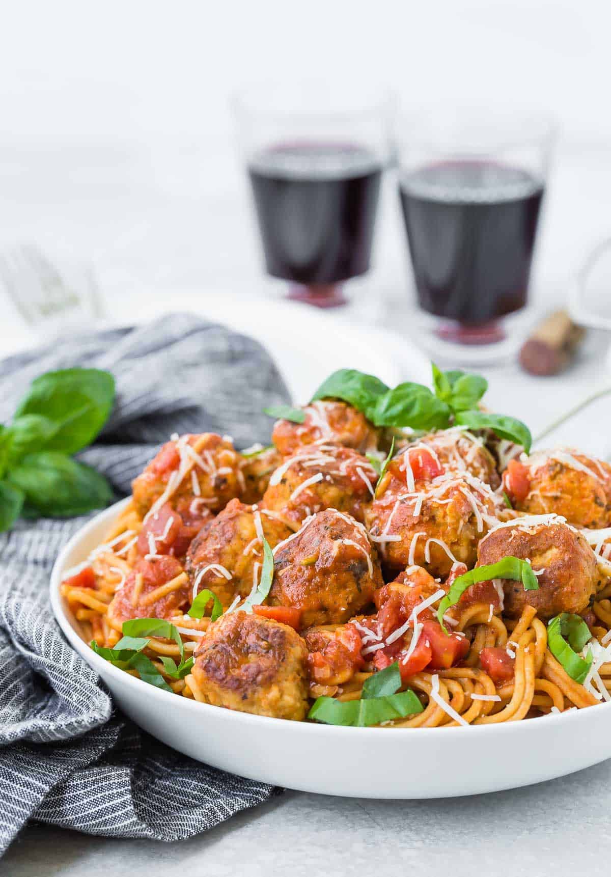 Spaghetti with meatballs, piled high in a white bowl.