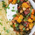 Close up overhead view of moroccan stew made with butternut squash, chickpeas and more. Served with couscous.