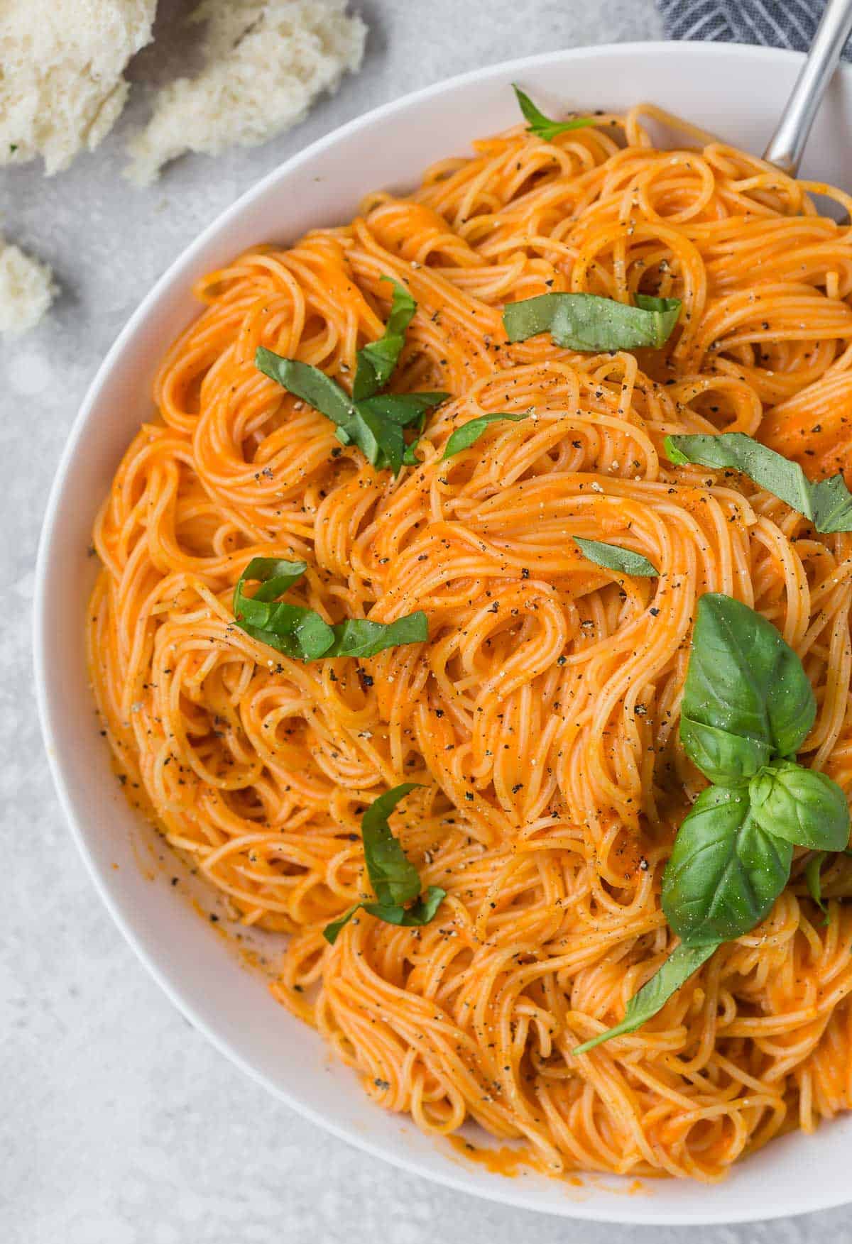 Large bowl of angel hair pasta with a simple roasted red pepper sauce.