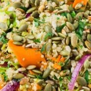 Colorful salad in a white bowl, text overlay reads "vegan quinoa salad with brussels sprouts"