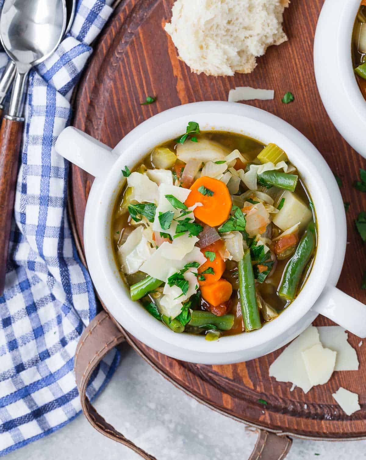 Bowl of soup with lots of vegetables: carrots, green beans, celery, cabbage and more.