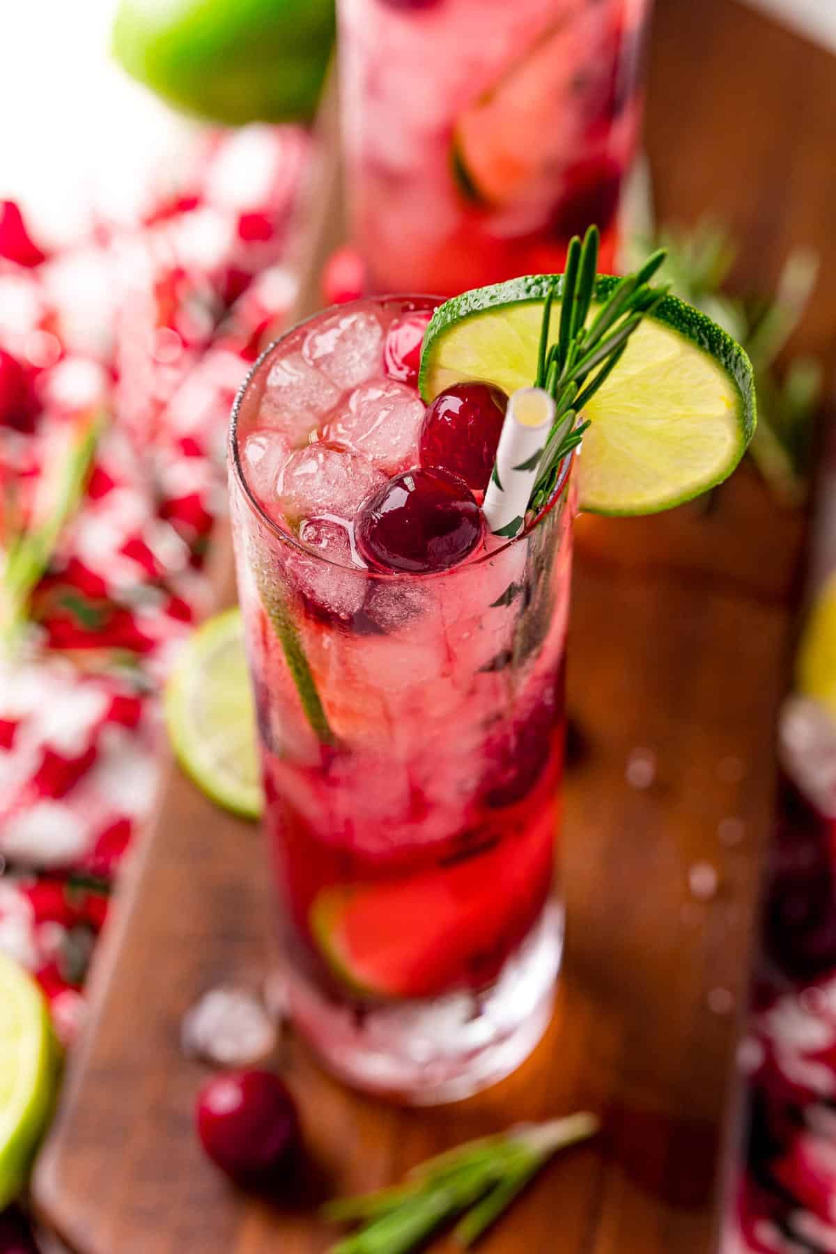 A bright red drink with cranberries and lime.