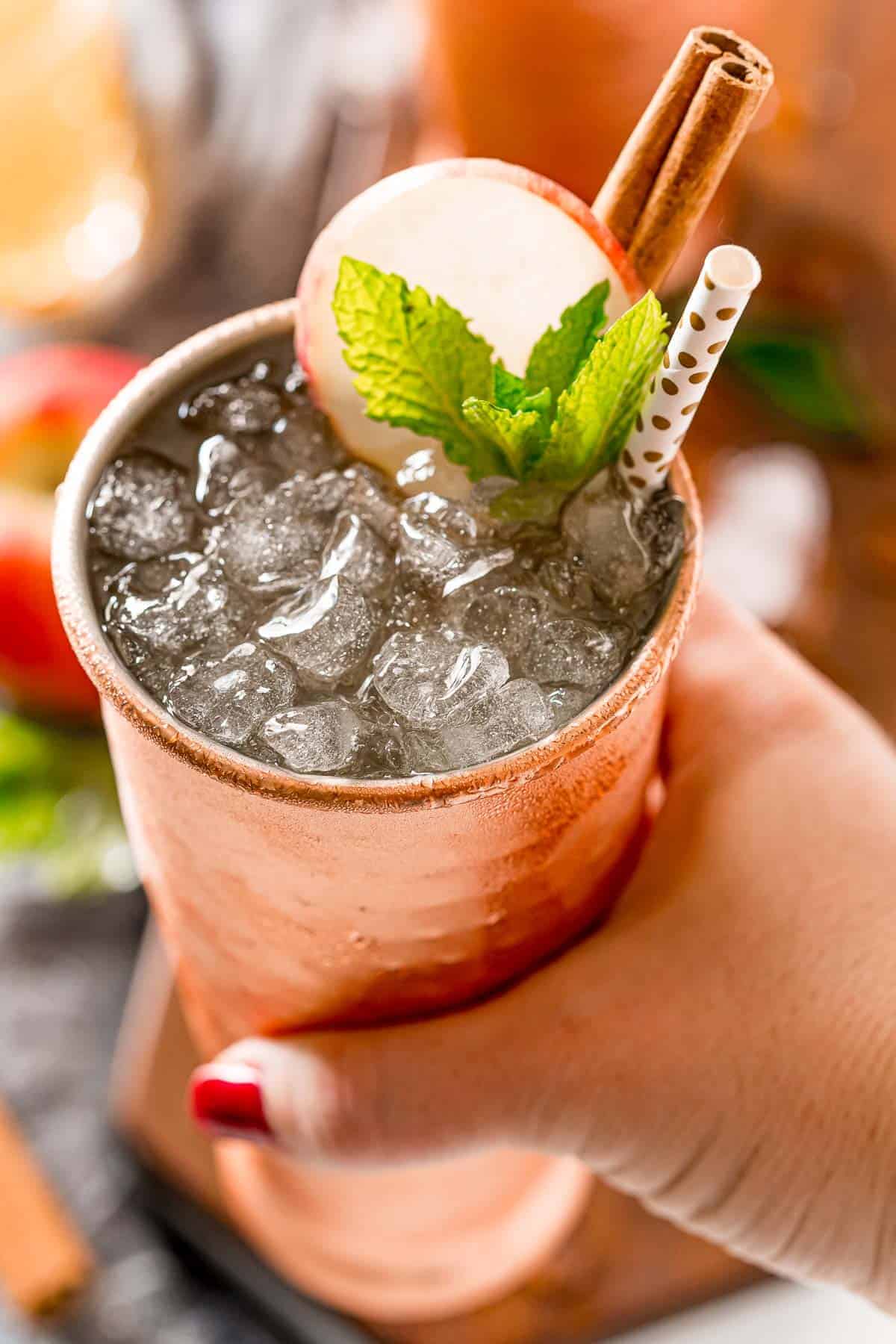 Apple cider moscow mule in a woman's hand.