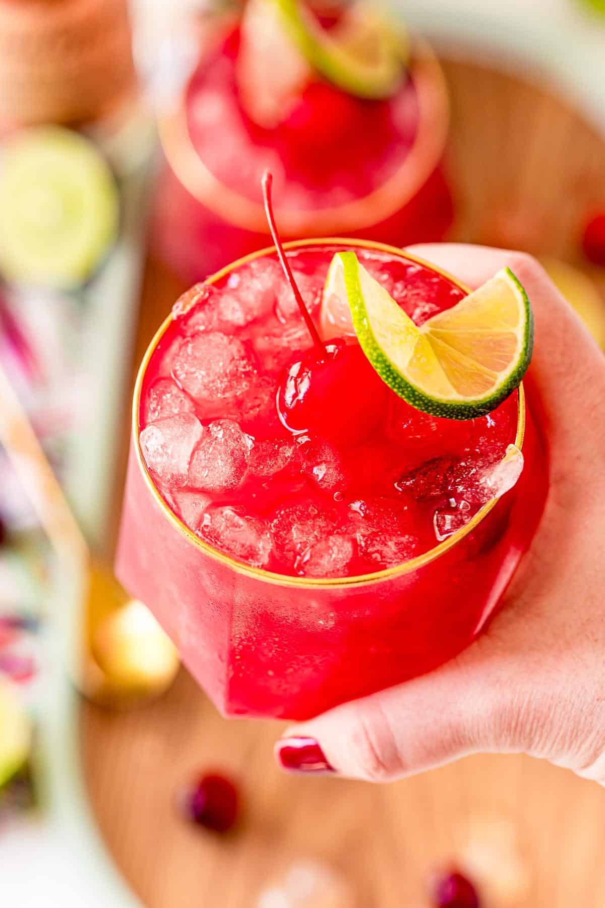 bright red cocktail in a person's hand.