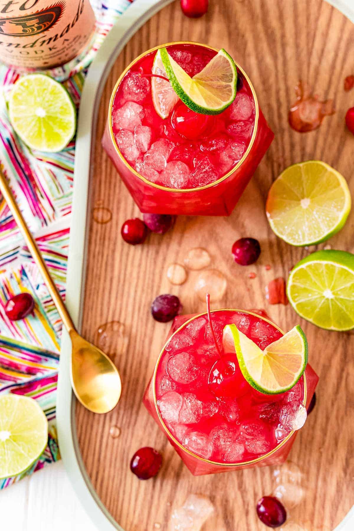 Overhead view of two bright red cocktails served on ice.