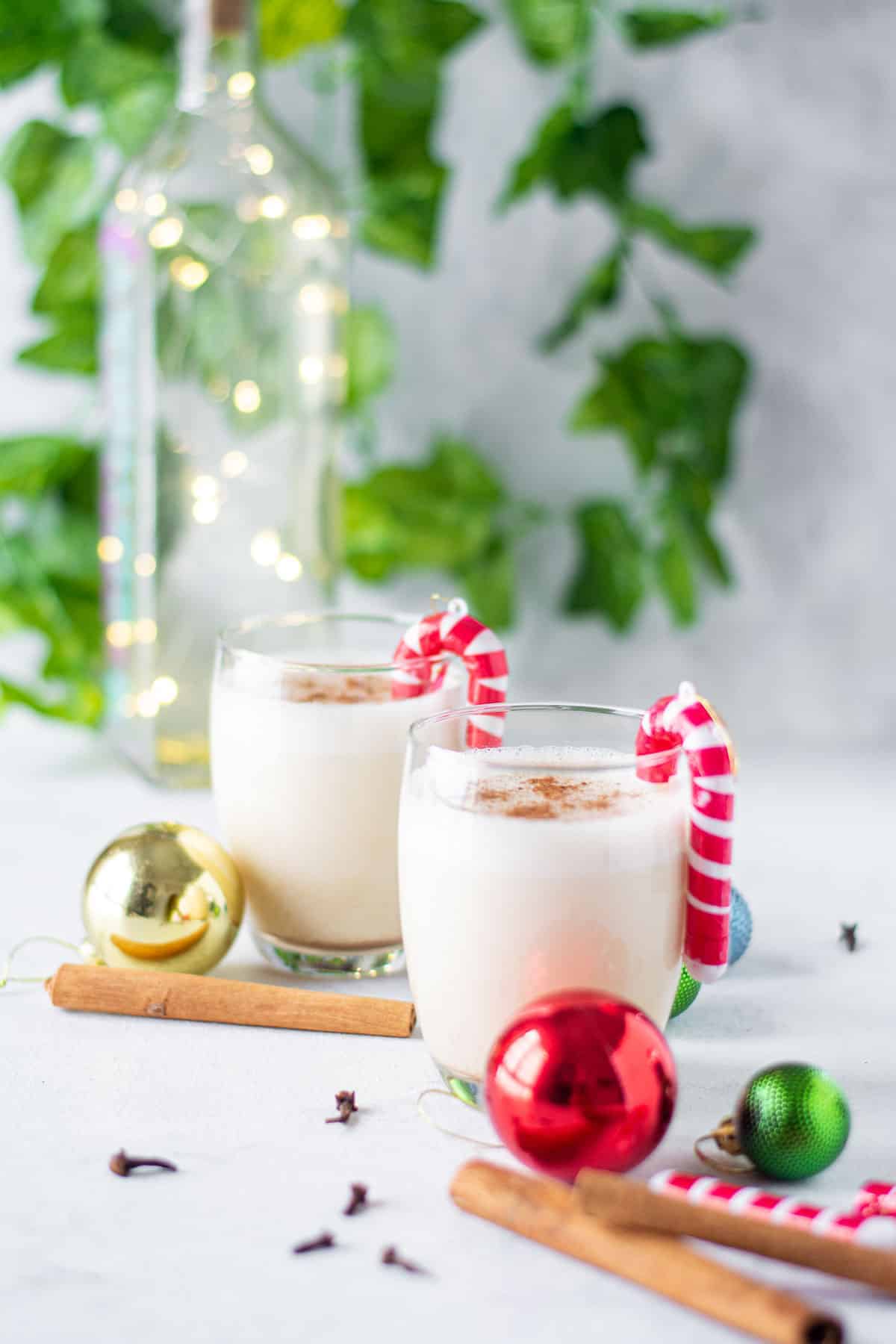 Two cocktails made with egg and milk in a festive holiday scene.