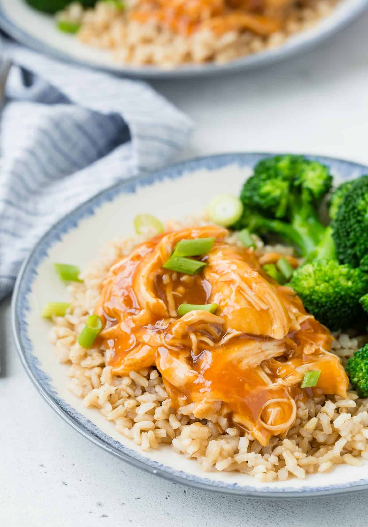 Honey sriracha chicken served over rice with a side of broccoli.