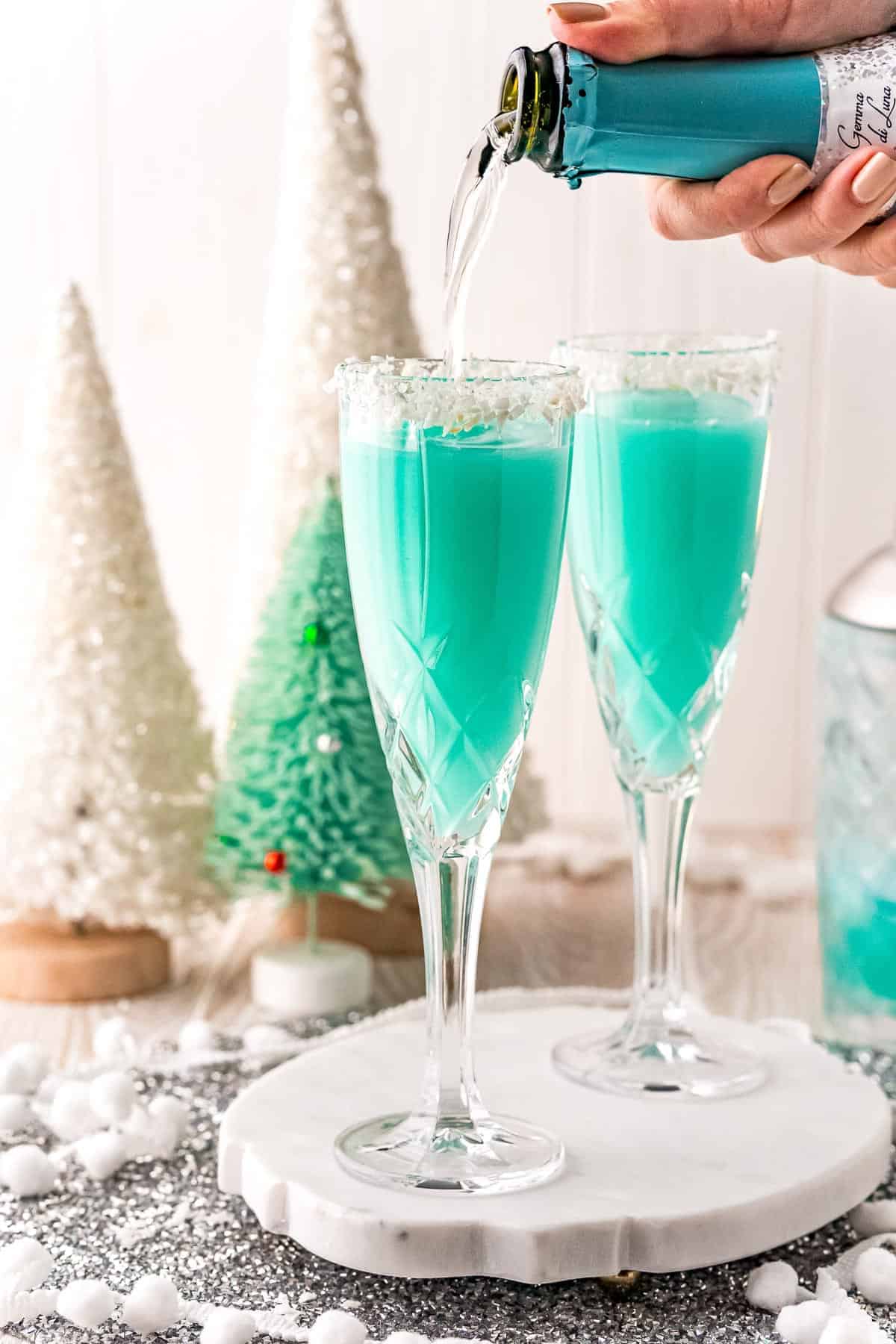 Prosecco being poured into a blue cocktail.