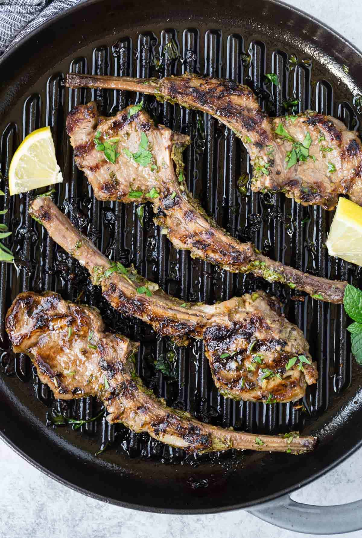 Round grill pan with cooked lamb chops.