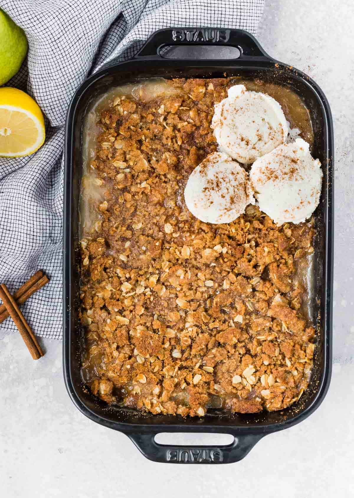 Overhead view of pear crisp topped with three scoops of ice cream.