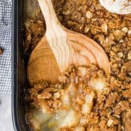 Crisp in a black baking dish, text overlay reads "pear crisp with ginger, rachelcooks.com"